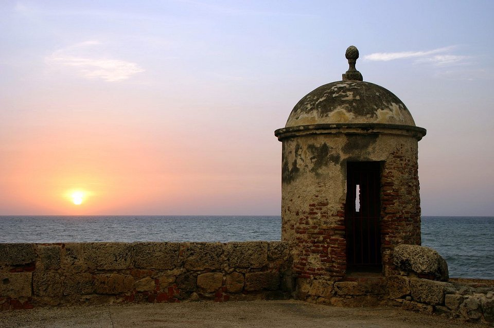 Garita de piedra de la muralla de Cartagena con el sol poniéndose sobre el mar
