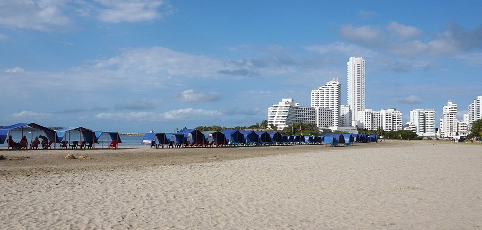 Playa de Bocagrande con toldos azules y edificios al fondo