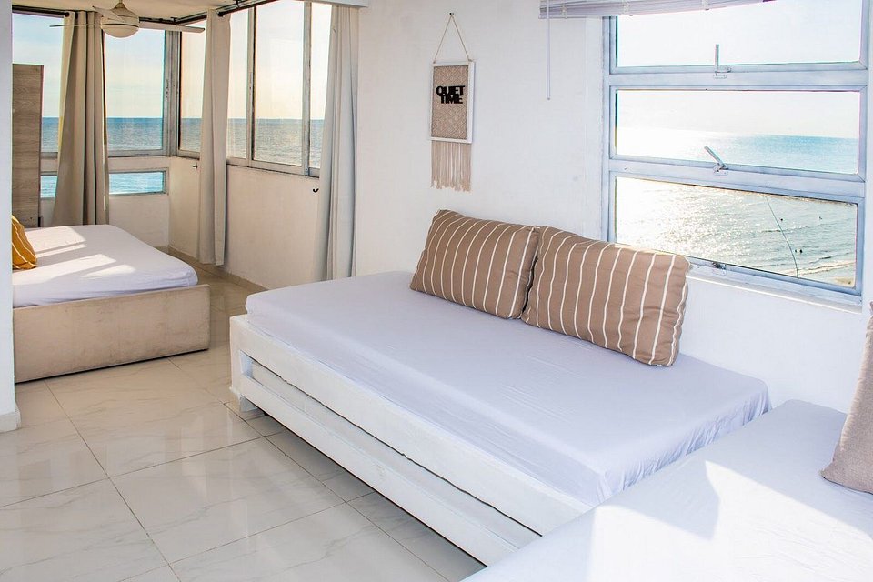Sala con sofá cama y ventanales en Ocean View 1108